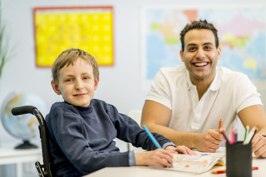 Smiling kid and therapist looking at the camera